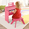 Kids playing on a pink 25-key piano with a matching stool, perfect for toddlers' musical exploration.