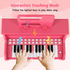 25-key pink kids piano keyboard with hands on keys, featuring interactive teaching mode for toddlers' musical fun.