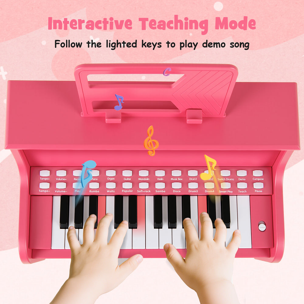 25-key pink kids piano keyboard with hands on keys, featuring interactive teaching mode for toddlers' musical fun.