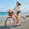 Pink 26-inch beach cruiser bike for women with a woven basket, riding along the coast, perfect for leisurely outings.