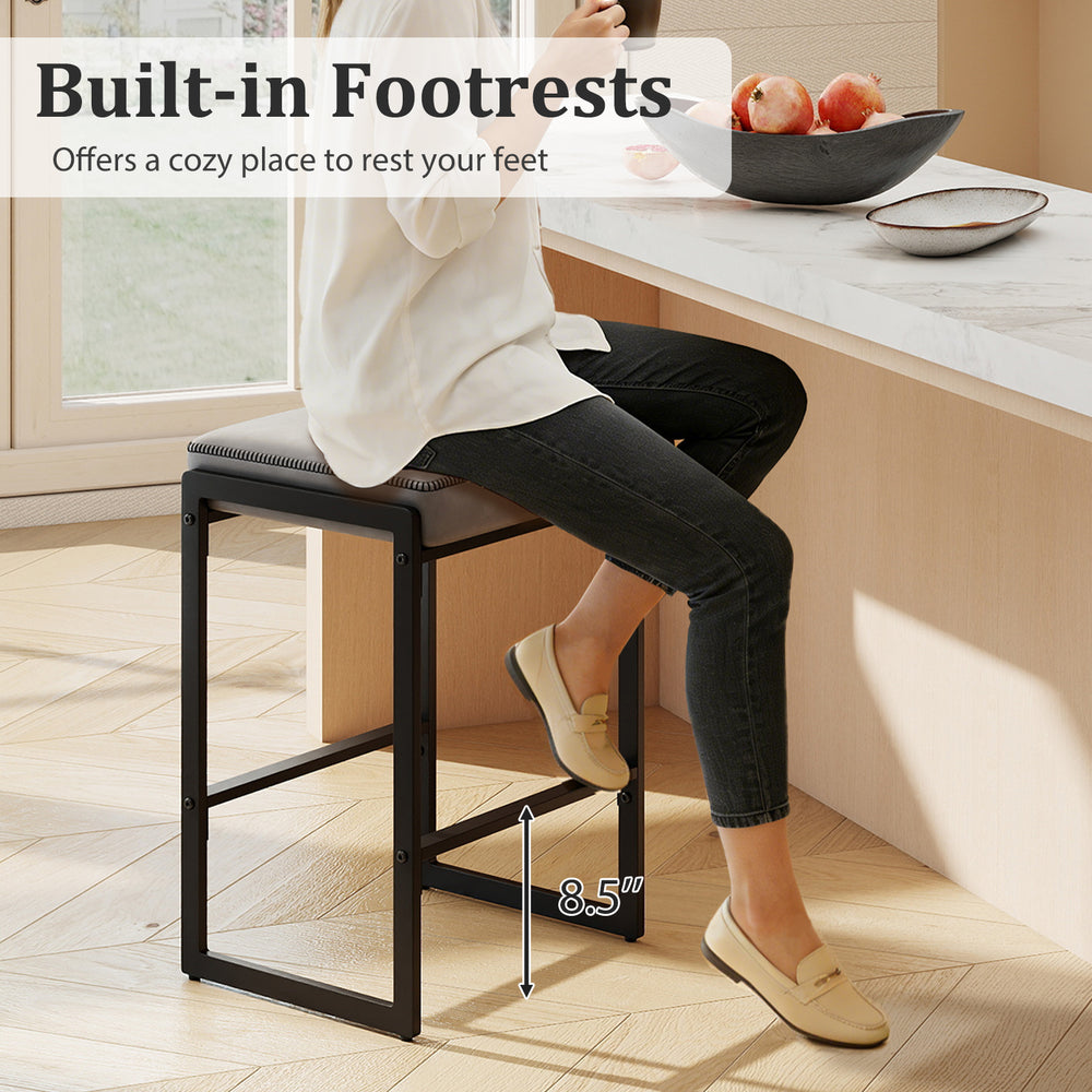 Counter height bar stool with gray faux leather seat and built-in footrest, perfect for kitchen islands and dining.