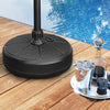 Fillable round umbrella base stand made of HDPE, designed for stability at poolside or garden, with storage groove.
