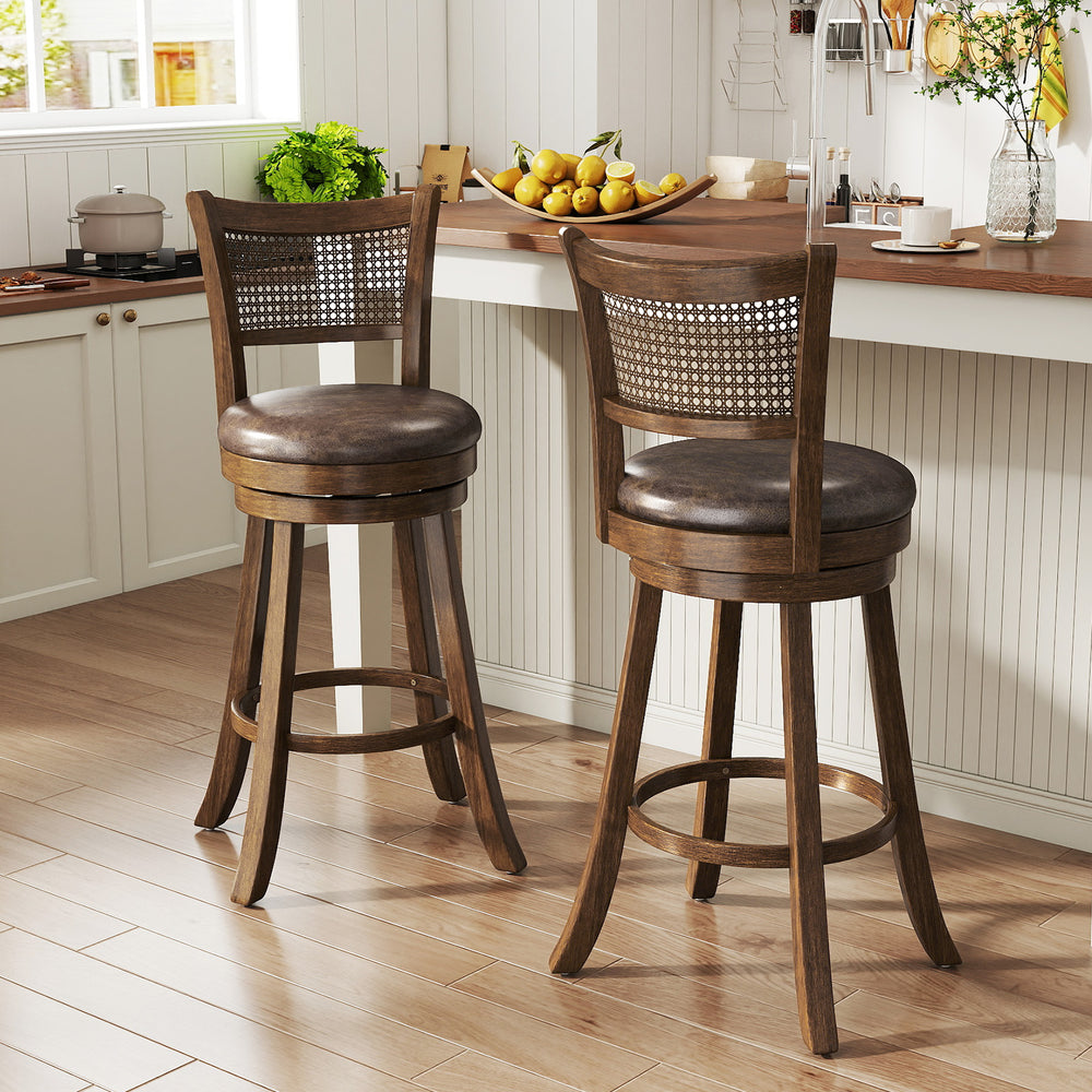 Set of 2 brown swivel counter height barstools with rattan backrest and footrest, ideal for kitchen islands.