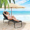 Foldable black lounge chair with adjustable backrest, perfect for beach use and elevated for comfort on sand.