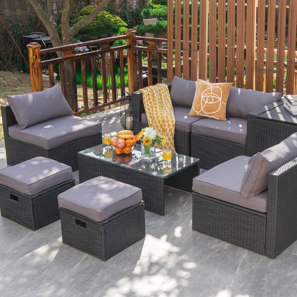 8-piece gray patio rattan furniture set with soft cushions, tempered glass table, and storage ottomans for outdoor.