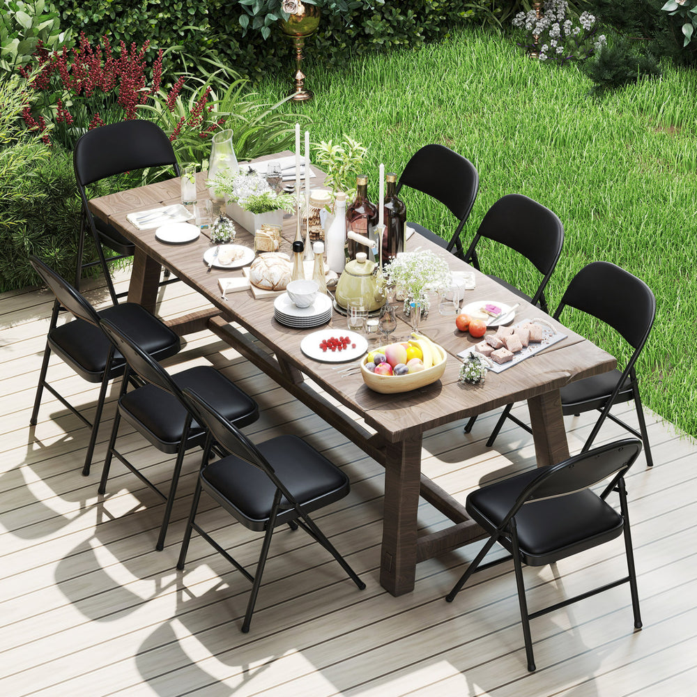 Black folding chairs with metal frame and PVC leather, arranged around a dining table for outdoor gatherings.