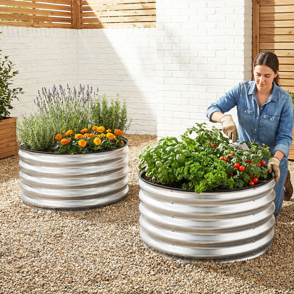 Two galvanized raised garden beds with open-ended bases, filled with herbs and flowers, perfect for outdoor gardening.