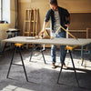 Heavy-duty sawhorse with steel folding legs, supporting up to 275 lbs, ideal for workspace setup and portability.