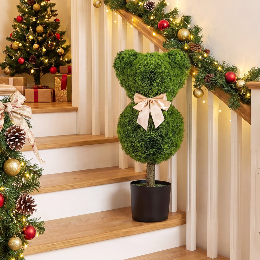 Bear-shaped topiary tree with golden bow in a black pot, perfect for festive decor and playful photo areas.