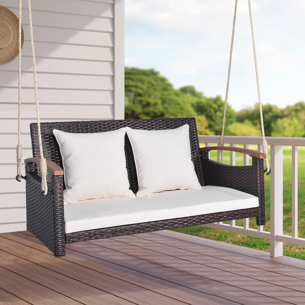 2-person patio rattan porch swing with cushions, sturdy hemp ropes, perfect for backyard or garden relaxation.