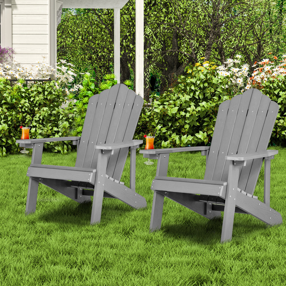 Two ergonomic silver Adirondack chairs in a backyard setting, perfect for outdoor relaxation and porch use.