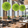 Bright green artificial plant topiary balls hanging in a restaurant, ideal for vibrant indoor decoration.
