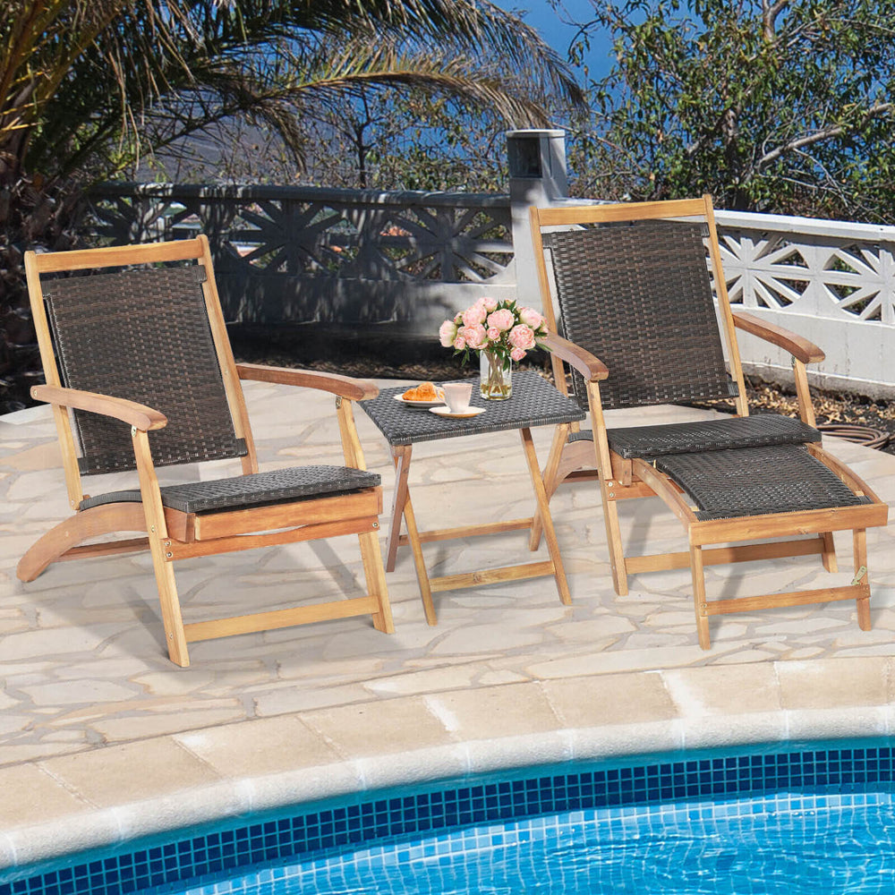 Two folding lounge chairs with retractable ottoman and acacia wood table, perfect for poolside relaxation.