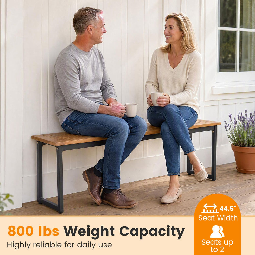 Two-person outdoor dining bench with acacia wood seat and metal legs, featuring an 800 lbs weight capacity for versatile use.