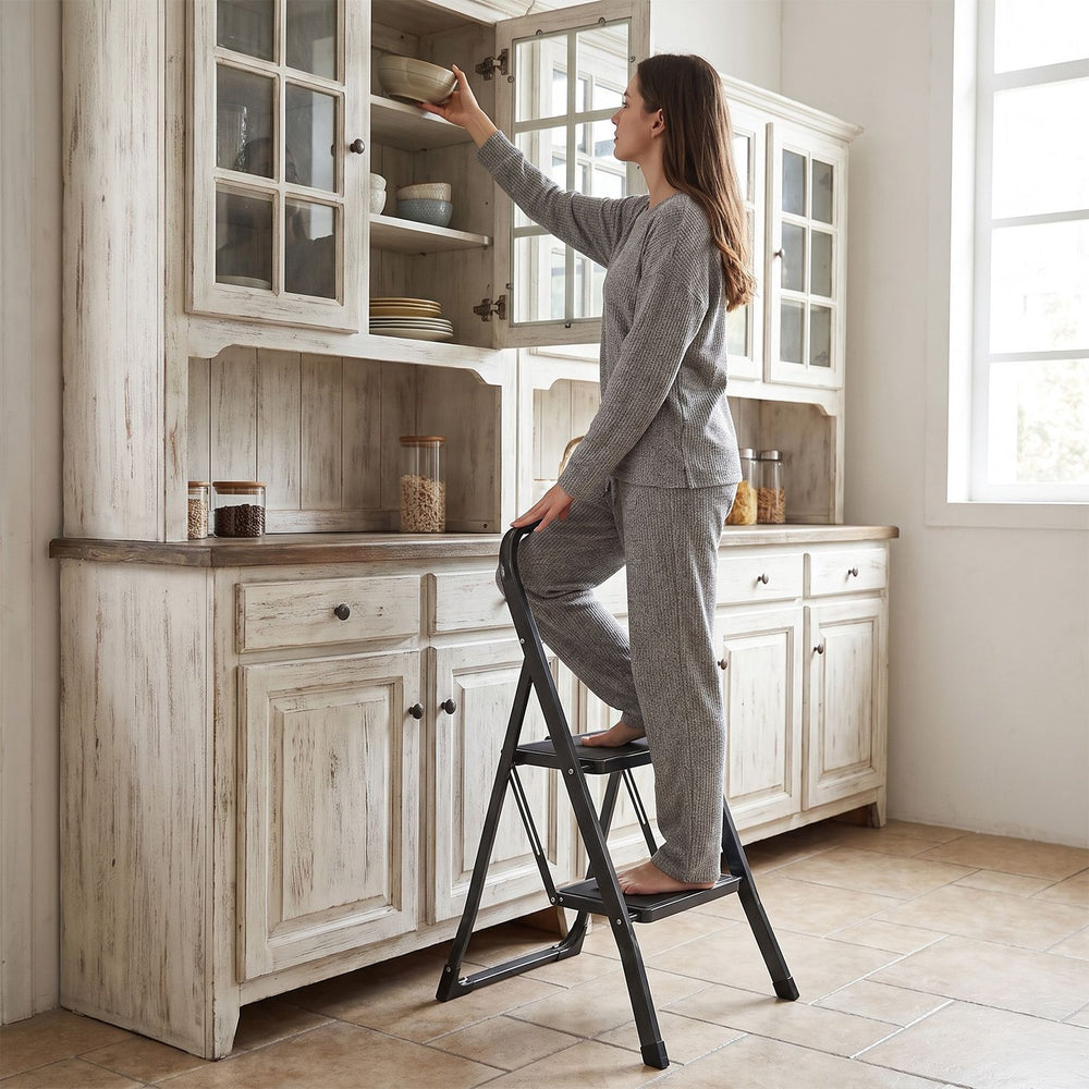 Two-step folding ladder with handrail and wide anti-slip pedals, ideal for reaching cabinets and everyday tasks.