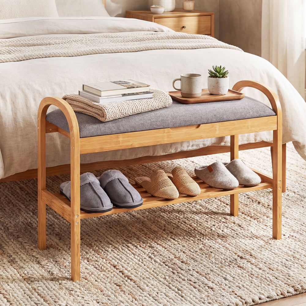 Bamboo shoe bench with gray padded cushion, featuring a slatted shelf for storage, perfect for entryway or bedroom use.