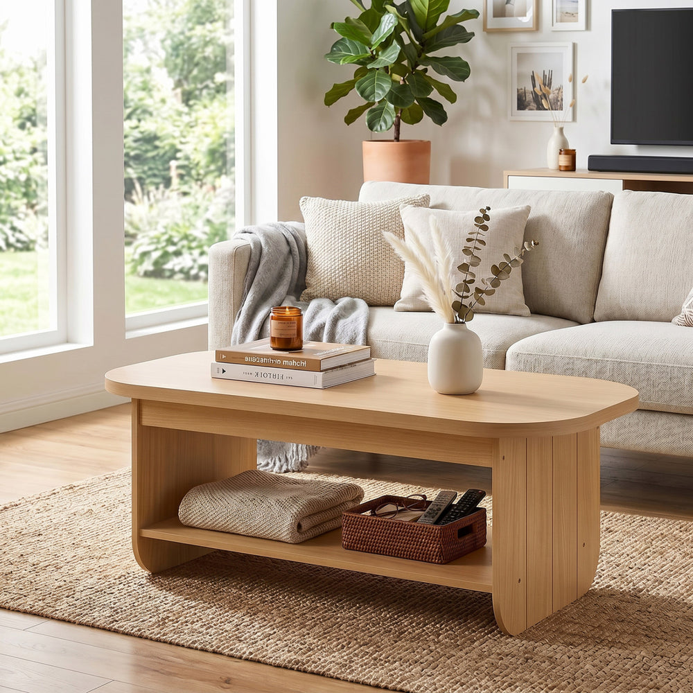 Natural 2-tier oval coffee table with bottom storage shelf, featuring a minimalist design for living room or office use.