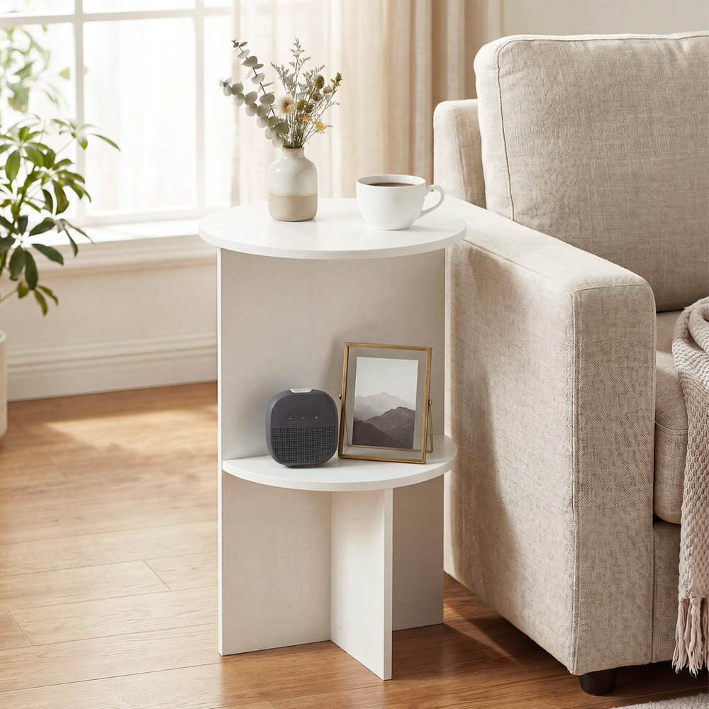 Round white side table with dual-layer storage shelf, perfect for small spaces in living rooms or bedrooms.