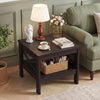 Brown square side table with X-frame design, showcasing a decorative lamp and floral arrangement for a cozy living room.
