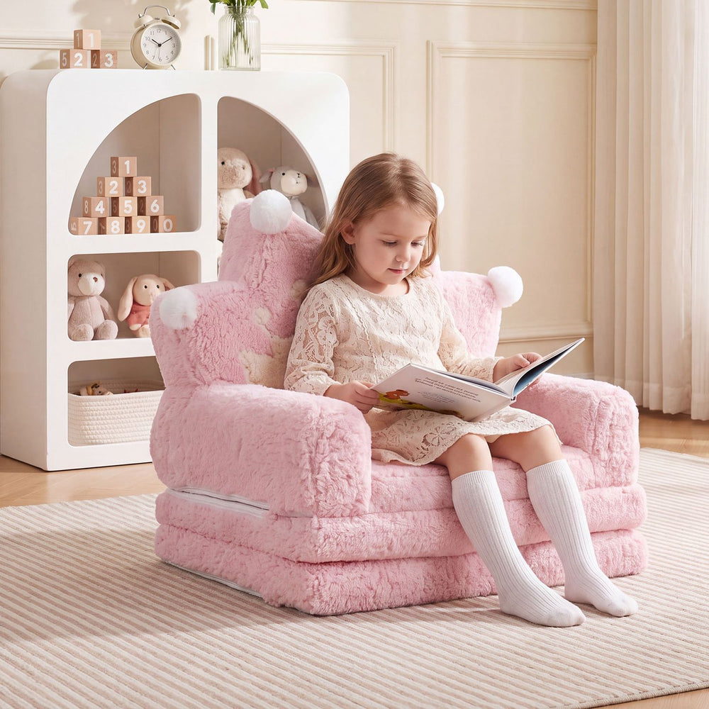 Foldable pink kids sofa bed with removable slipcover, perfect for reading and lounging in a cozy space.
