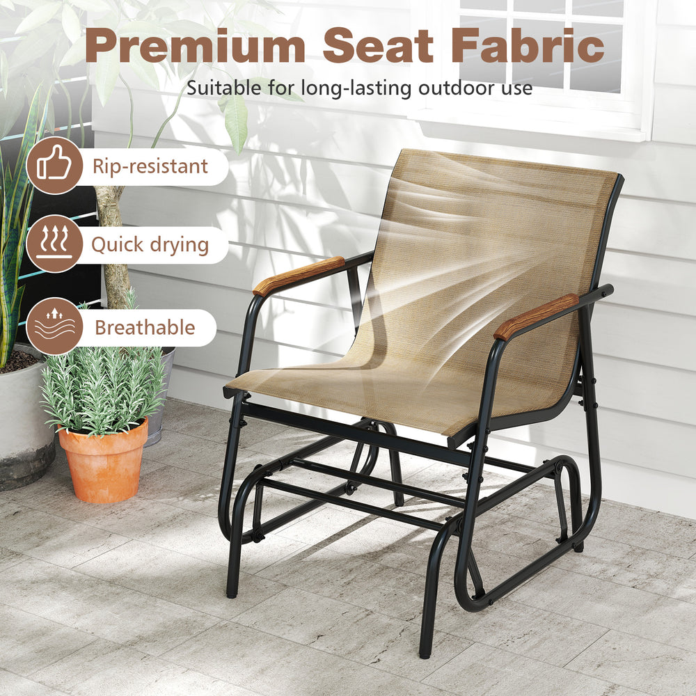 Single outdoor glider chair with breathable fabric and teak wood armrests, perfect for backyard relaxation.