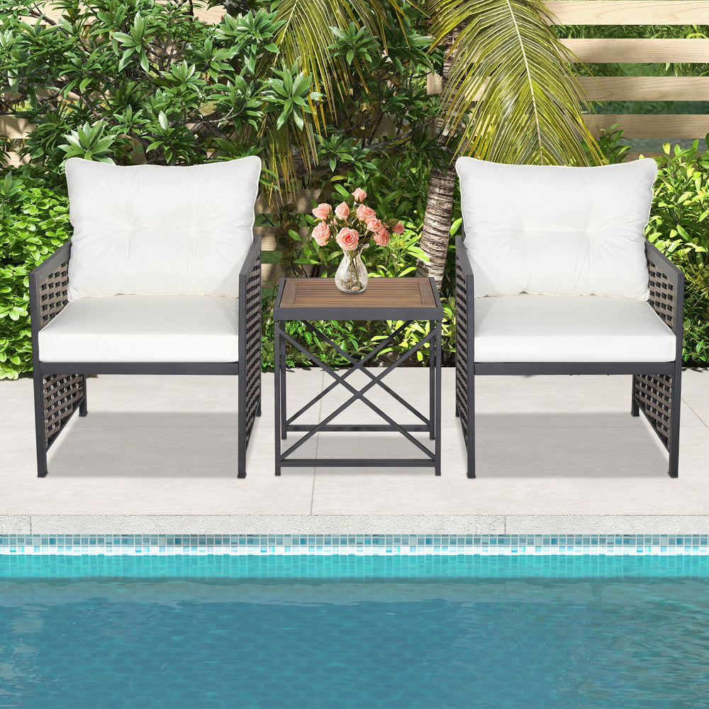 Two white cushioned chairs with a wooden tabletop in a patio rattan furniture set, perfect for poolside relaxation.