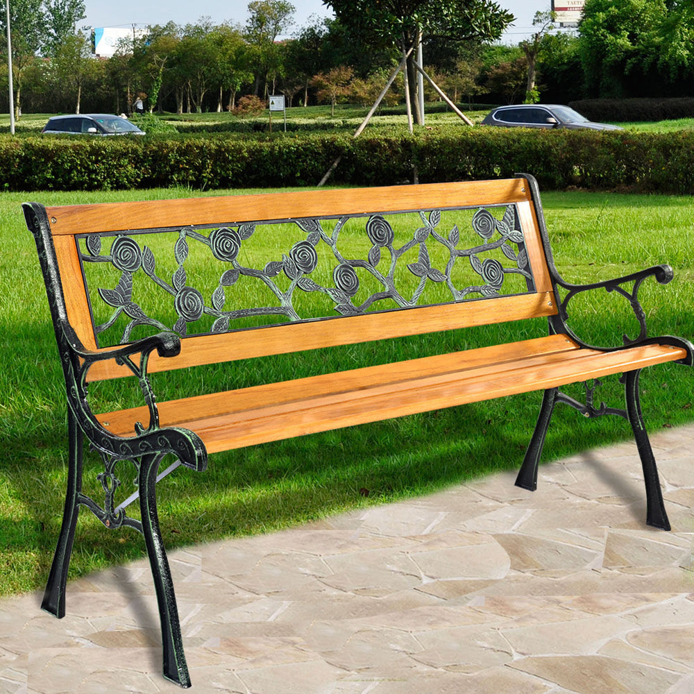 Patio park garden bench with a solid wood seat, iron cast structure, and floral PVC backrest, comfortably seats three.