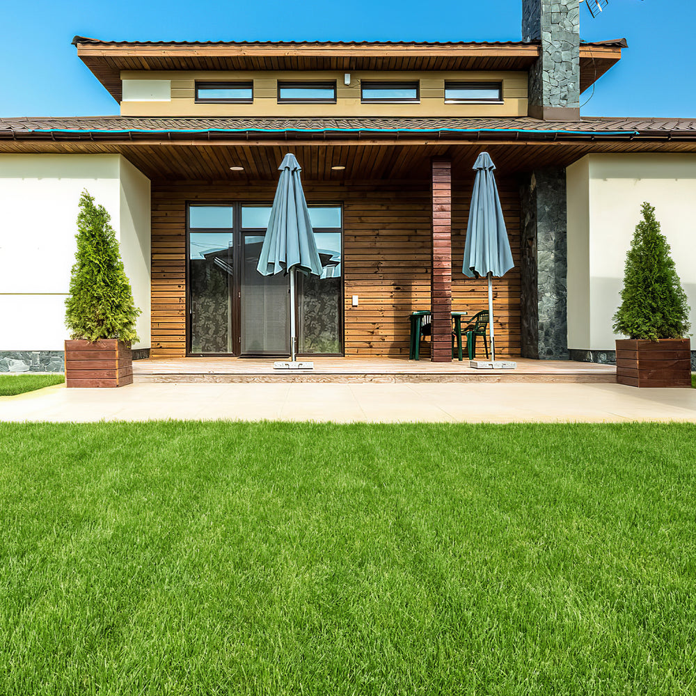 Interlocking artificial grass tiles in a lush green setting, ideal for low-maintenance indoor and outdoor use.