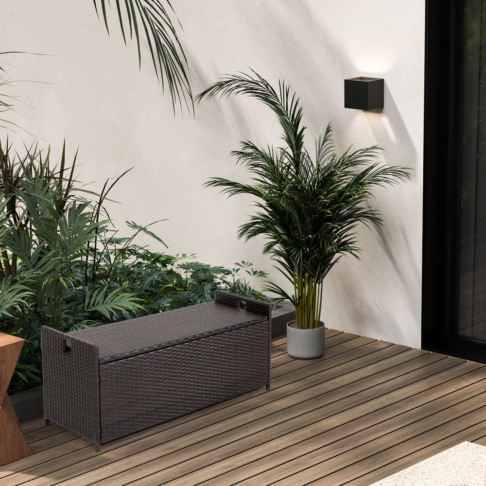 Patio storage bench with seat cushion, made of brown PE rattan, ideal for outdoor seating and storage.