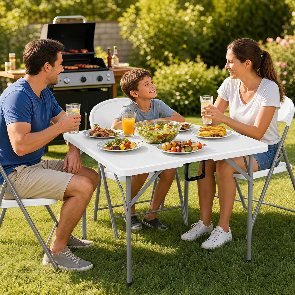 Family enjoying a meal at the 34-inch square foldable card table with a white HDPE top in a garden setting.