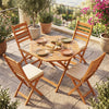 Octagonal acacia wood outdoor folding dining table for 4, featuring a slatted tabletop, set in a garden patio setting.