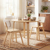 Round dining table with rubber wood legs, designed for small spaces, perfect for 4 people in a cozy kitchen setting.