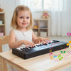 Child playing the 37 Keys Kids Piano Keyboard in black, featuring 8 rhythms, microphone, and safe design for fun music.