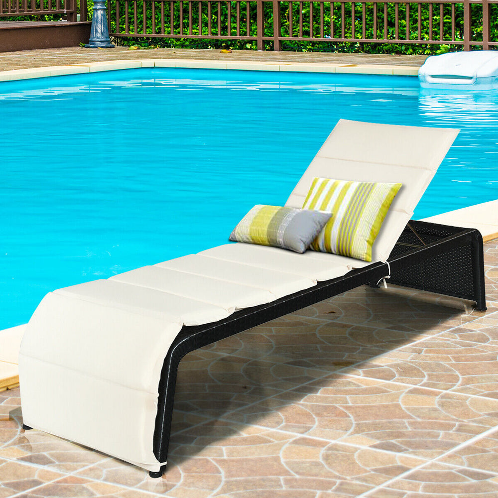 Patio rattan lounge chair with adjustable back, cushioned in white, perfect for poolside relaxation.
