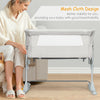 Portable beige bedside crib with mesh sides, adjustable height, and detachable mattress for safe baby sleep.