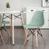 Modern green plastic hollow chair with wood legs, ergonomic design, perfect for dining rooms and contemporary decor.