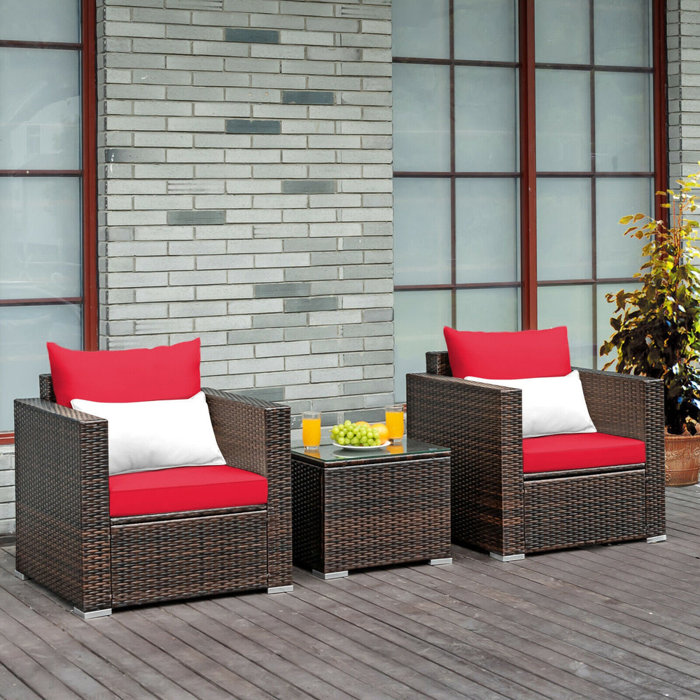 Two red-cushioned rattan chairs with a glass-top table, perfect for outdoor patio relaxation and gatherings.