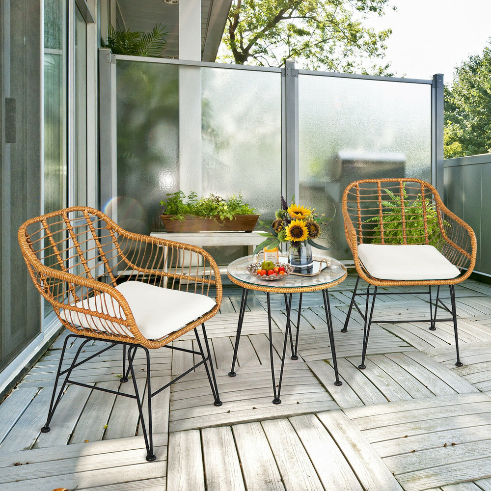 Two cushioned rattan chairs and a round coffee table, perfect for outdoor patio relaxation and entertaining.