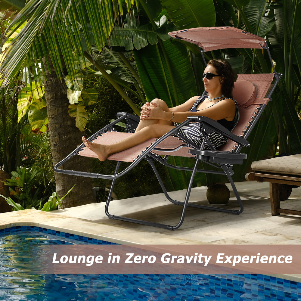 Folding recliner lounge chair with adjustable shade canopy and cup holder, perfect for outdoor relaxation by the pool.