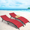 Two red folding patio lounger chairs with cushions on a beach, perfect for sunbathing and outdoor relaxation.