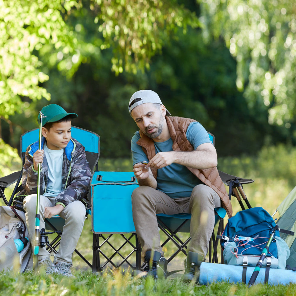 Two portable folding camping chairs in blue with cup holders, set up outdoors for relaxation and convenience.