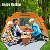 Family enjoying a picnic inside the orange 3-4 person pop-up beach tent with UPF 50+ sun protection in a forest setting.