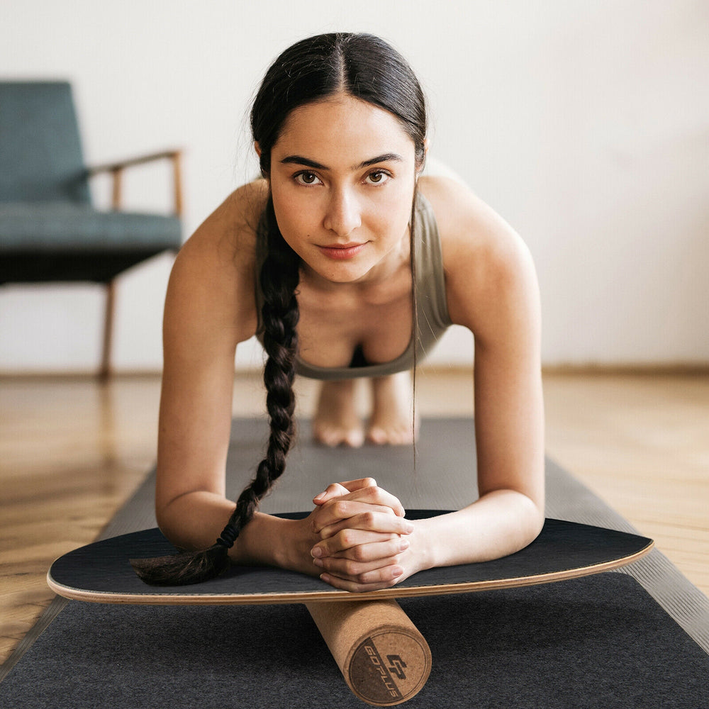 Balance board trainer in use for core strength, featuring birch wood and cork for durability, ideal for home workouts.