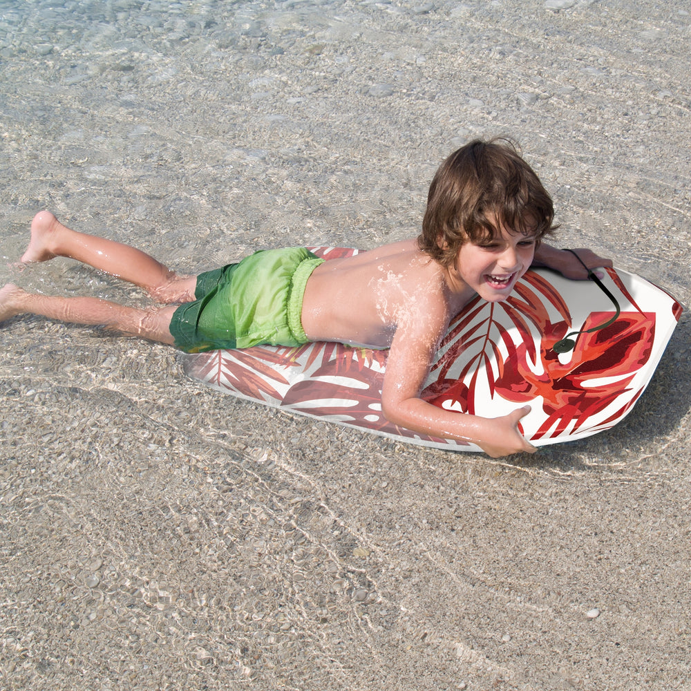 Child enjoying the 41-inch lightweight surfboard with a floral design in shallow water, perfect for summer fun.