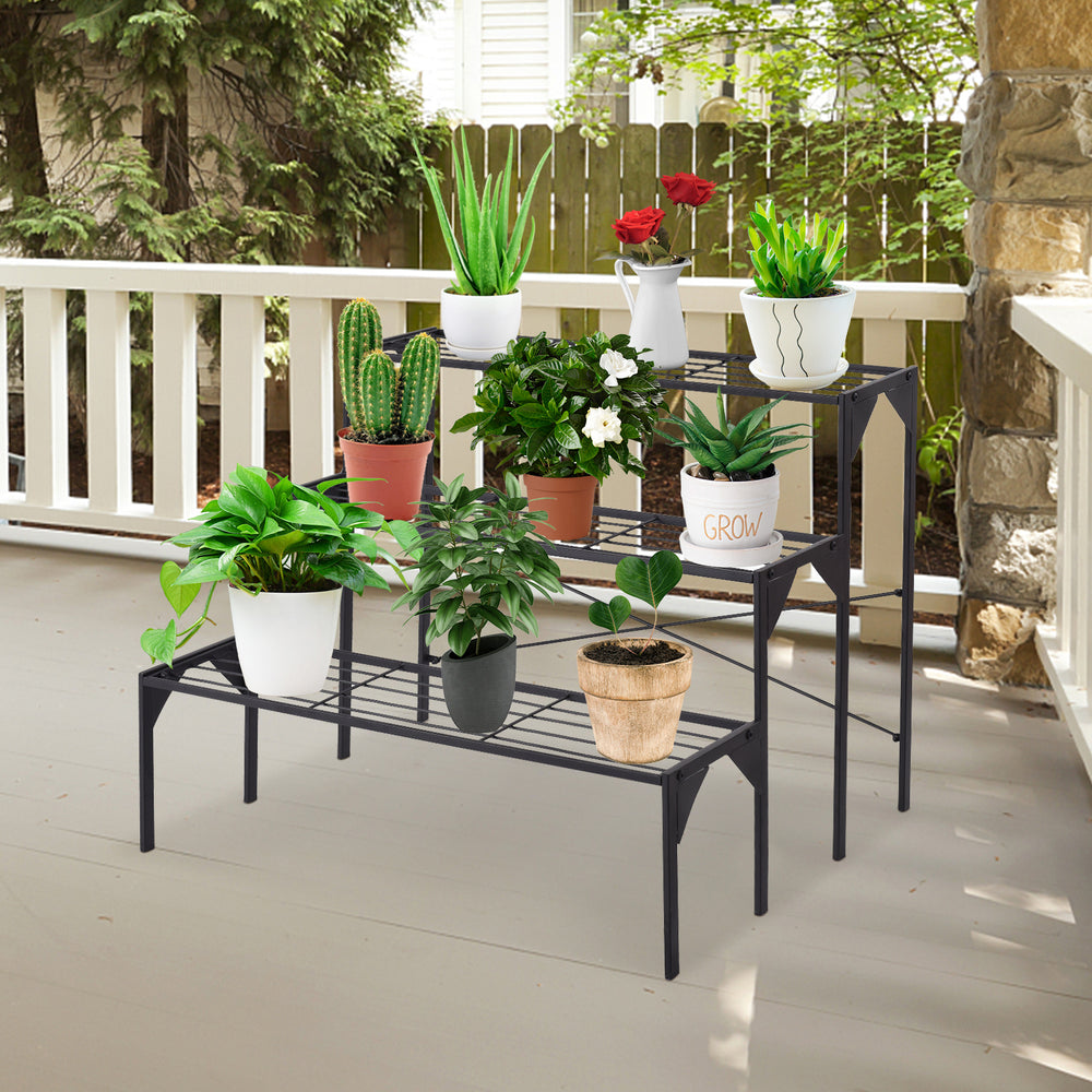 Three-tier metal plant stand showcasing various potted plants, ideal for outdoor patio decor and organization.