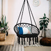Cushioned black hammock swing chair with tassels, designed for comfort and stability, ideal for indoor or outdoor.