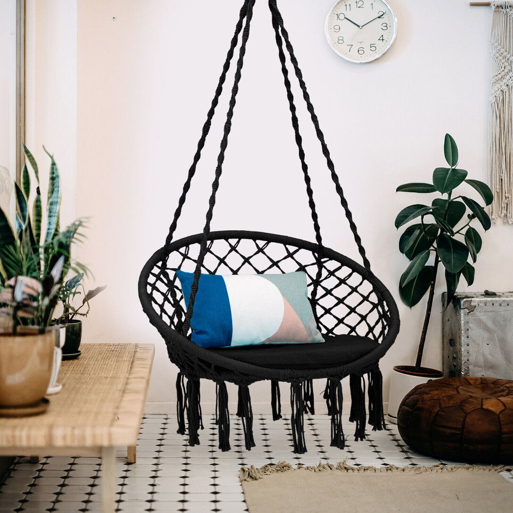 Cushioned black hammock swing chair with tassels, designed for comfort and stability, ideal for indoor or outdoor.