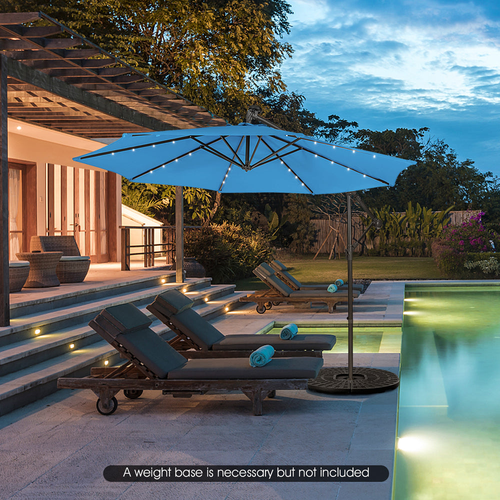 10 feet blue patio solar-powered cantilever umbrella with LED lights, tilted for optimal shade by the poolside.