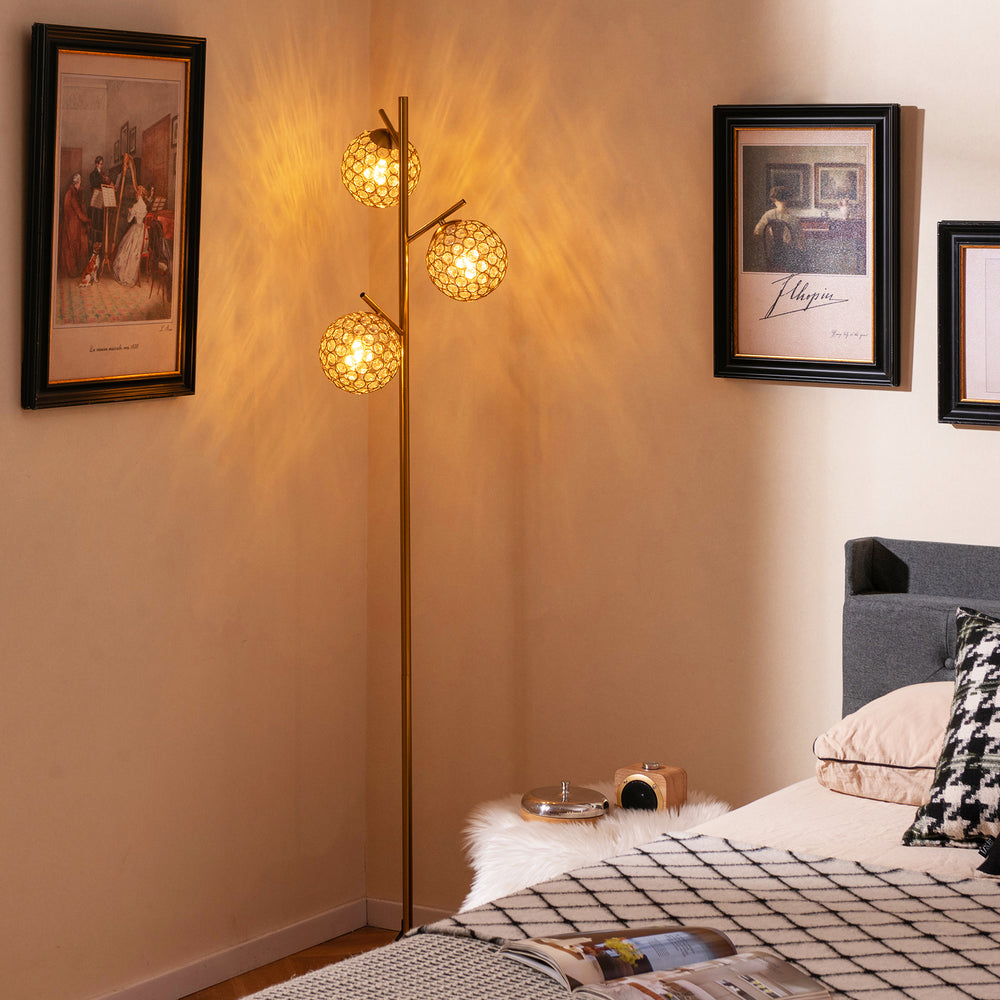 Three-globe floor lamp in gold with acrylic shades, foot switch, and a stable base, perfect for home or cafe lighting.