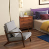 Modern accent chair with grey cushion and wooden frame, perfect for bedroom relaxation and comfort.